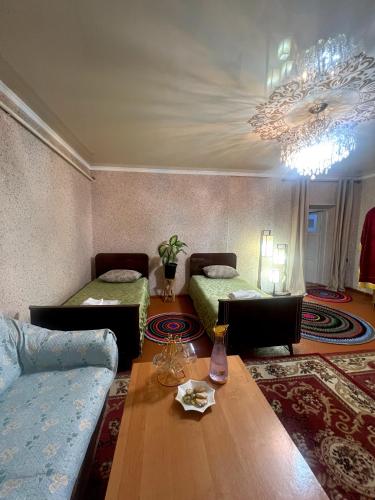 a living room with two beds and a table at Azamat in Kara-Koo