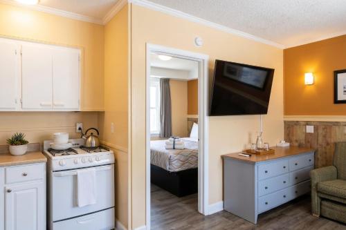a room with a kitchen and a bedroom with a bed at Colonial Inn in Nags Head