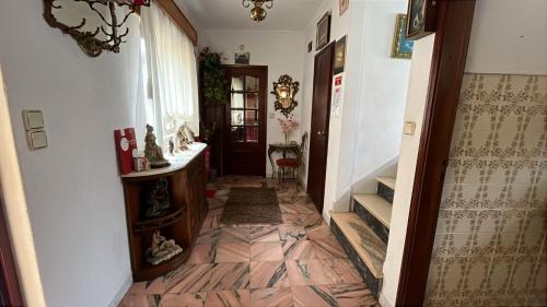 a hallway with a tile floor and a staircase at Grandma Luísa's Corner in Verdelhos