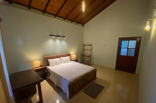 a bedroom with a bed and a table and a window at Elegance Cottage in Dagonna