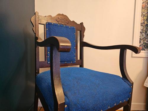 a chair with a blue seat with a blue cushion at Auberge Lever L'Ancre in Sainte-Hélène-de-Kamouraska