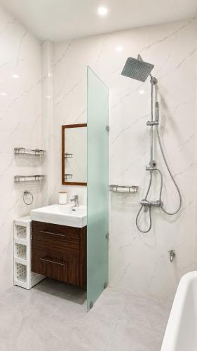 a white bathroom with a sink and a shower at Sherlock Home Pool Villa Krabi in Ban Chong Phli