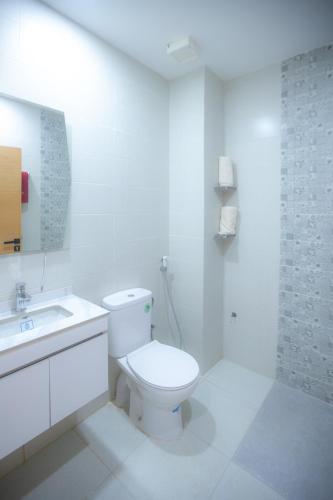a white bathroom with a toilet and a sink at Hola Rio in Dakhla