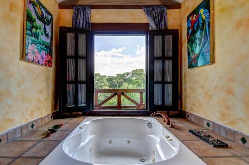 a large bath tub in a room with a window at Toucan Suite @ Mahogany Hall in San Ignacio