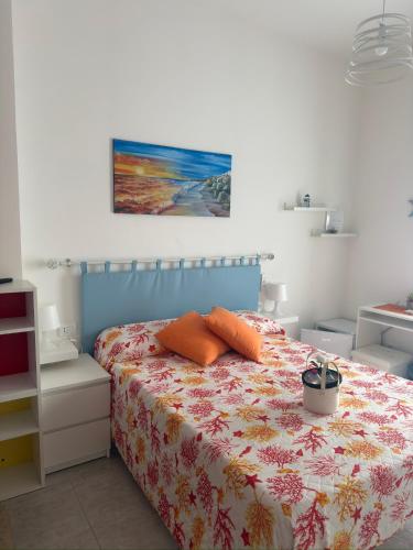 a bedroom with a bed with orange pillows on it at B&B Sunset da carla in Agropoli