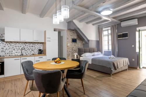 a kitchen and a bedroom with a bed and a table at Studio apartman Oreb in Vela Luka