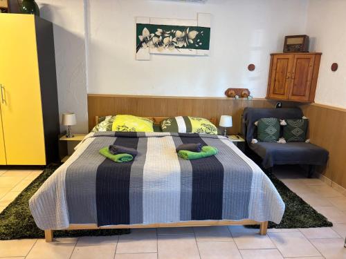 a bedroom with a bed and a chair at Horváth Apartmanház in Szigliget