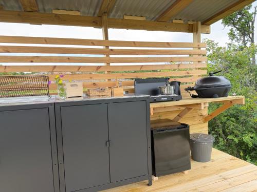 eine Außenküche mit einer hölzernen Pergola in der Unterkunft Seglinge Glamping in Norrön