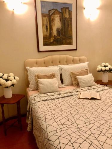 a bedroom with a bed with a painting on the wall at Chalé do Vale à 10 min de carro de Itacoatiara in Niterói