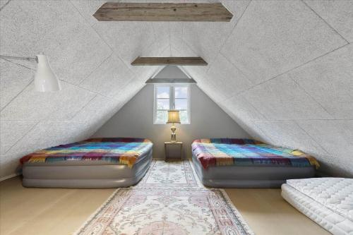 a attic bedroom with two beds and a window at FA028-Karise-Tagerupvej-29 in Karise