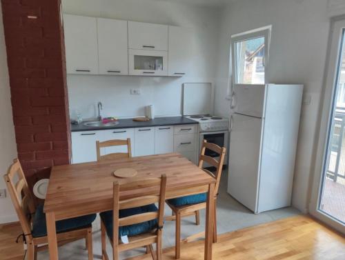 a kitchen with a wooden table and a refrigerator at Drinika in Foča
