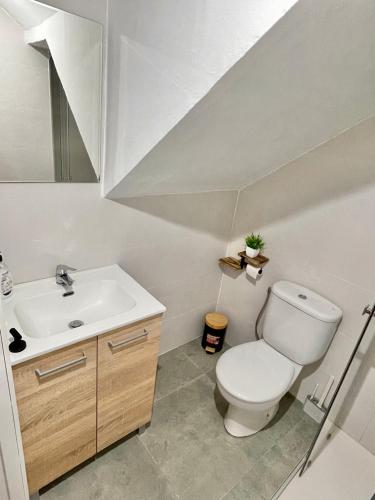 a bathroom with a white toilet and a sink at San Roque 7 in Archidona
