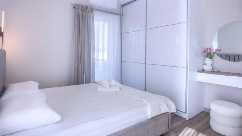a white room with a bed and a mirror at Orelia Suite 3 in Karistos