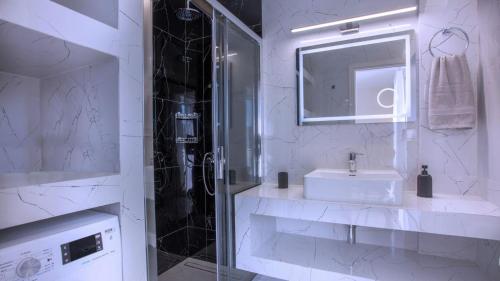 a white bathroom with a sink and a shower at Orelia Suite 3 in Karistos