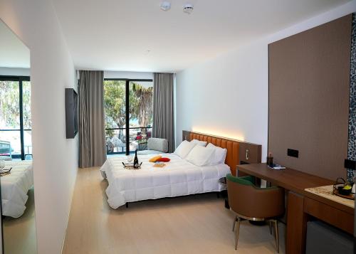 a hotel room with a white bed and a desk and a desk at Aeon Blue in Selianitika