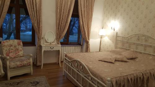 a bedroom with a bed and a chair and a mirror at Elegance Residence in Timişoara