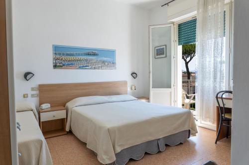 a hotel room with a bed and a window at Hotel Verbena in Lido di Camaiore