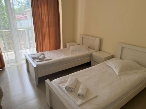 two beds in a room with a window at LizAna in Shekhvetili