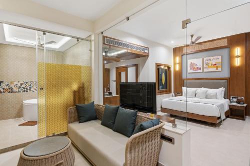 a living room with a bed and a couch and a bedroom at Amaari Beach Resort in Kanyakumari
