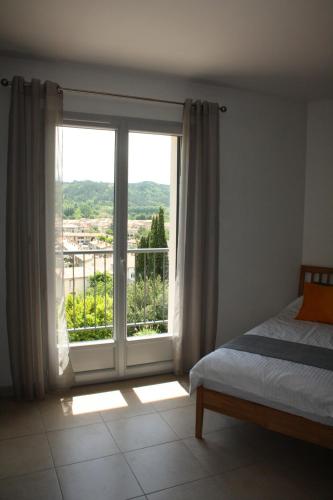 une chambre avec un lit et une grande fenêtre dans l'établissement Chemin Du Soula, à Couiza