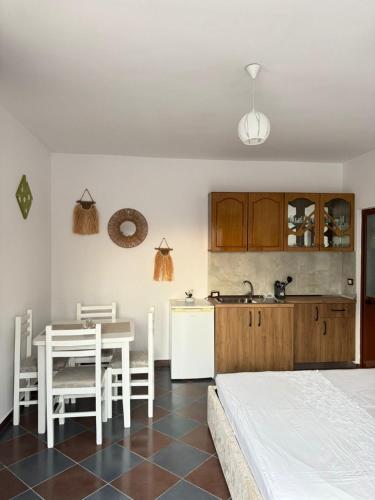 a kitchen and dining room with a table and a bed at N'Gjaci Guest House in Tale