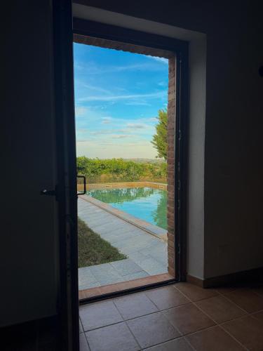 a door leading into a room with a view of a pool at Podere Tre Berte - The Sleeping Beauty in Acquaviva
