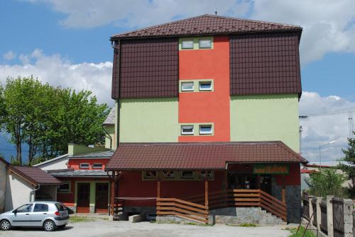 a tall building with a car parked in front of it at Penzión Slávia in Poprad