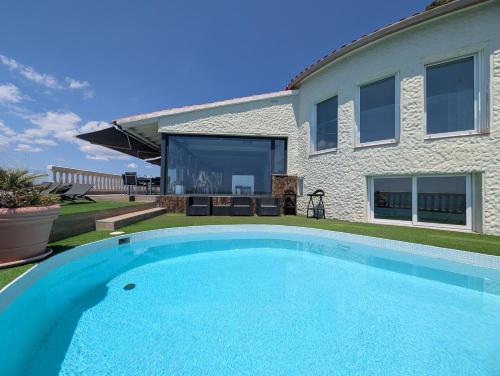 a large blue swimming pool in front of a house at GMID IMMO A228 Casa Unica in Roses