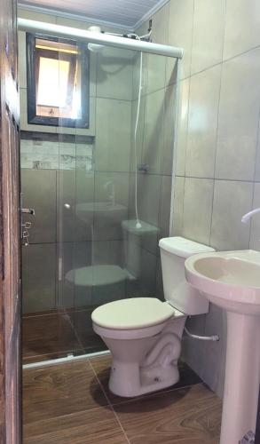 a bathroom with a toilet and a shower and a sink at Cabanas Brisa da Lagoa in Arroio do Silva