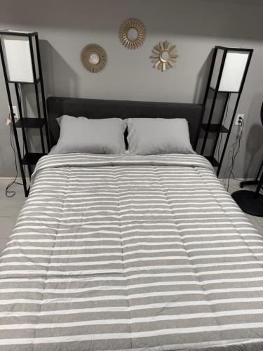 a large bed in a bedroom with two mirrors on the wall at 50 Private Lounge in Irvington