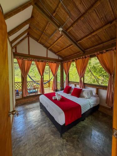 a bedroom with a large bed with red pillows at Cabaña ALAK in La Vega