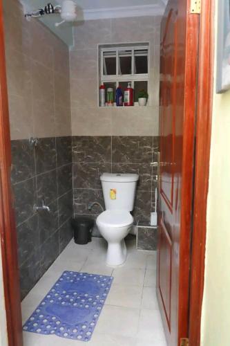 a small bathroom with a toilet and a shower at Bulleys BNB in Thika