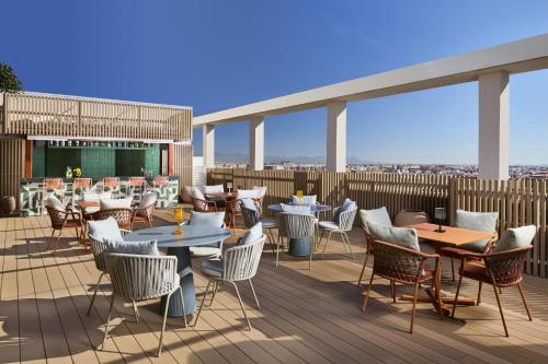 a patio with tables and chairs on a deck at NH Valencia Center in Valencia