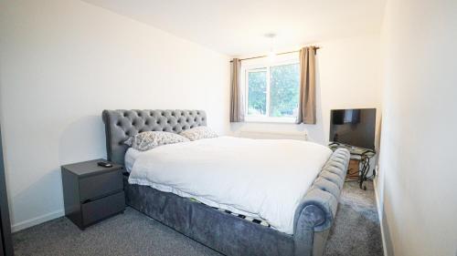 a bedroom with a large bed and a television at Whitebeam in Solihull