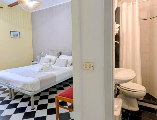 a bedroom with a bed and a toilet and a sink at Villa Fieschi Boutique Hotel in Lavagna