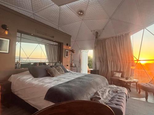 a bedroom with a large bed and a large window at Arequita Lodge in Minas
