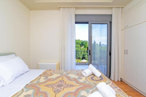 a bedroom with a bed with a large window at Azure Villa Kanoni in Análipsis