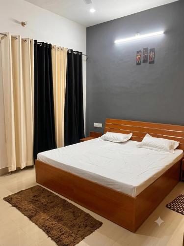 a bed in a bedroom with black curtains at Ramaya Retreat Ayodhya in Faizābād