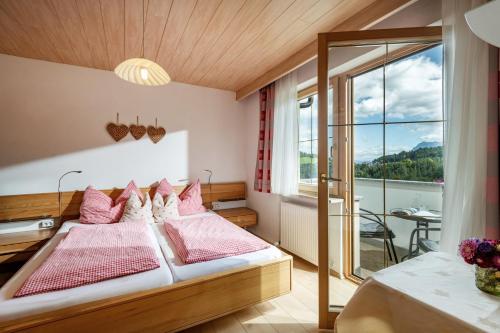 a bedroom with a bed and a large window at Haus Enzian in Thiersee