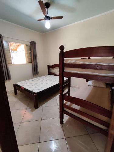 a bedroom with two beds and a ceiling fan at Chácara Mative Socorro SP in Socorro