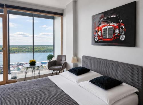 a bedroom with a bed with a red car on the wall at UP 34 FLOOR APARTMENTS in Klaipėda