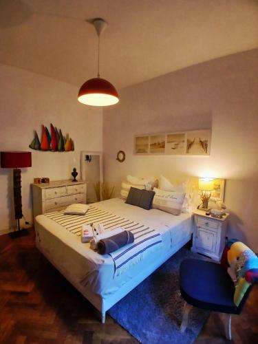 a bedroom with a large bed and a blue chair at Chambre au panier in Marseille