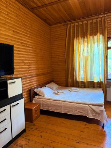 a small bedroom with a bed and a television at Садиба Каньйон in Kamianets-Podilskyi