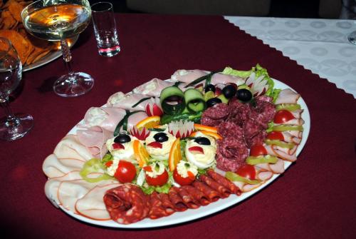 um prato de alimentos com carne e legumes sobre uma mesa em Penzión Slávia em Poprad