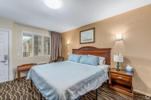 a hotel room with a bed and a window at Lumina Motel in Daytona Beach