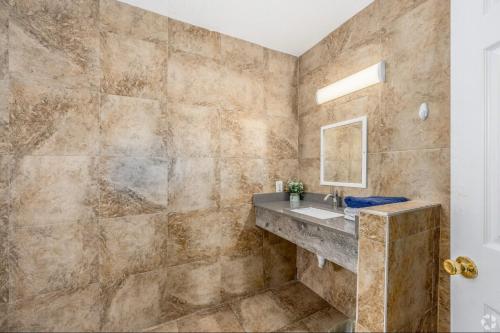 a bathroom with a sink and a mirror at Lumina Motel in Daytona Beach