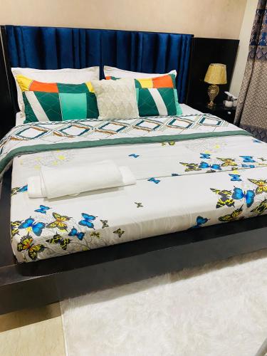 a bed with a comforter with blue flowers on it at Qlbs sweet room in Abidjan