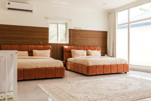 ein Schlafzimmer mit zwei Betten und einem großen Fenster in der Unterkunft ALSARA HiDEAWAY in Qūr