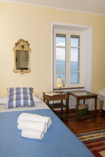 a bedroom with a bed with towels on it at Villa Supina - 3BDR with Pool & Panoramic Lake Garda Views in Toscolano Maderno