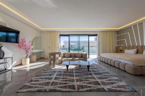 a bedroom with a bed and a couch and a table at Villa Horizon Marrakech in Marrakesh